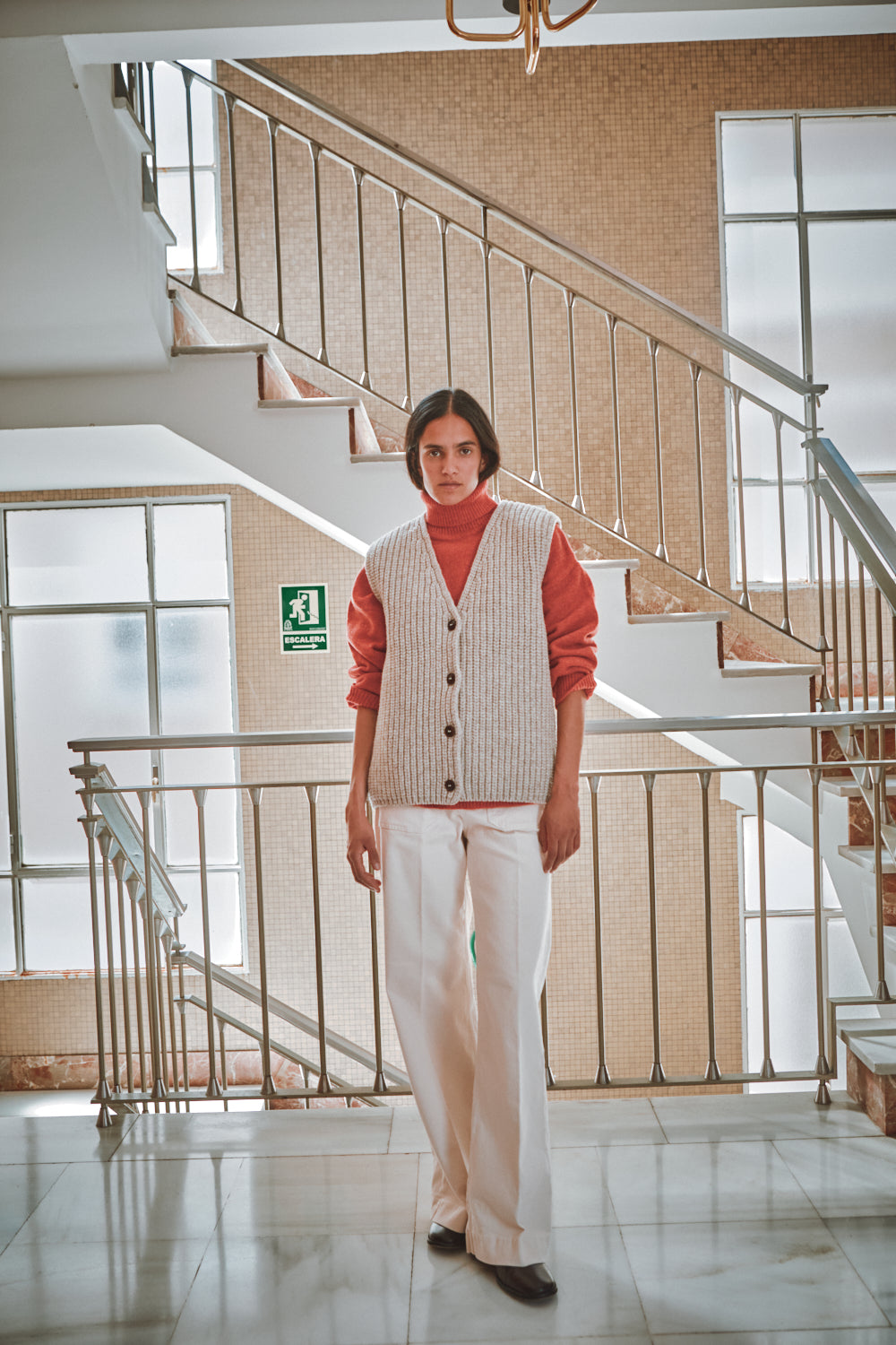 Person standing in a modern building interior with a staircase.