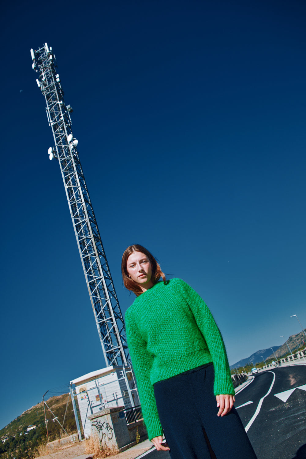 Person wearing a green sweater standing 