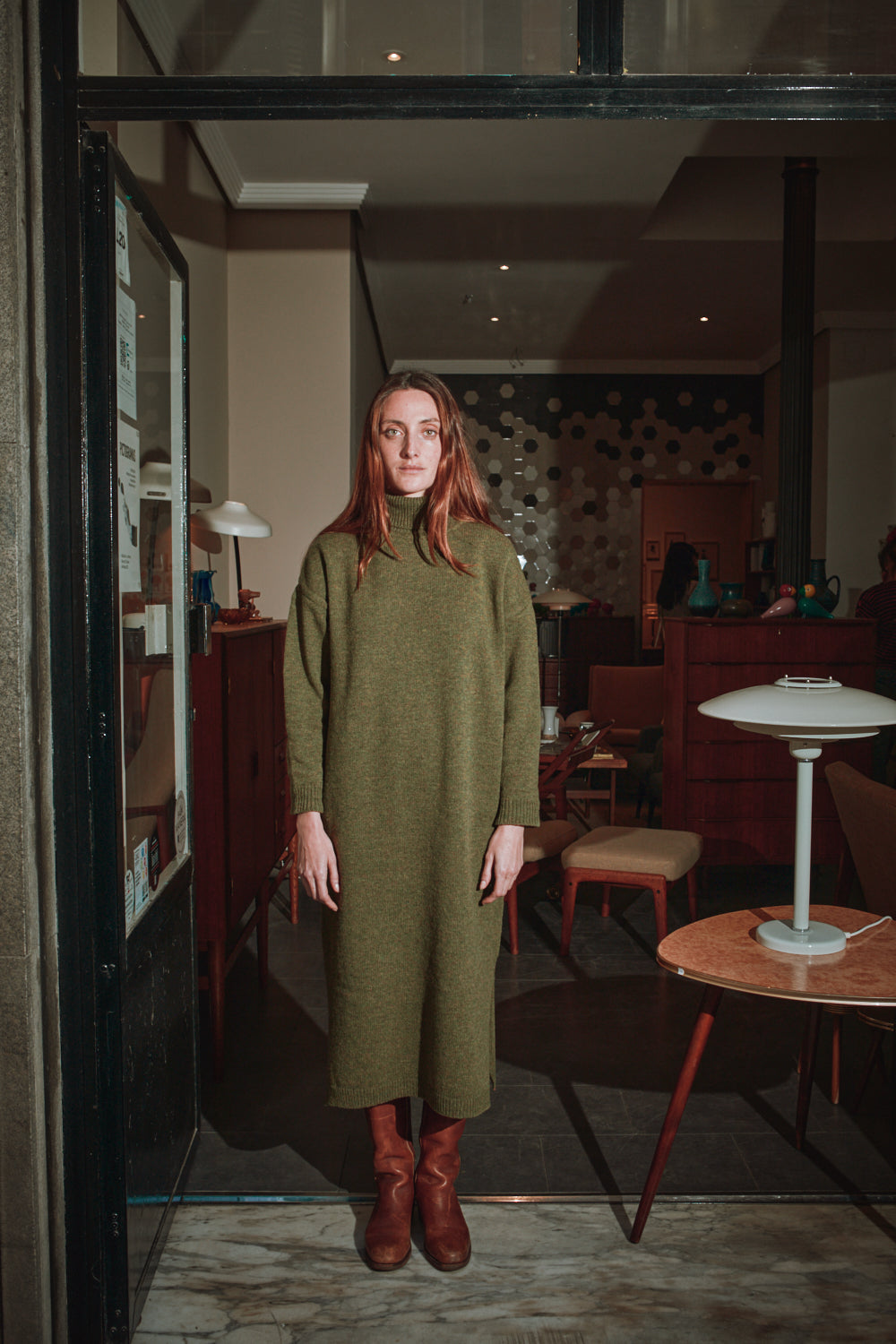 Woman in a green dress standing in a restaurant interior