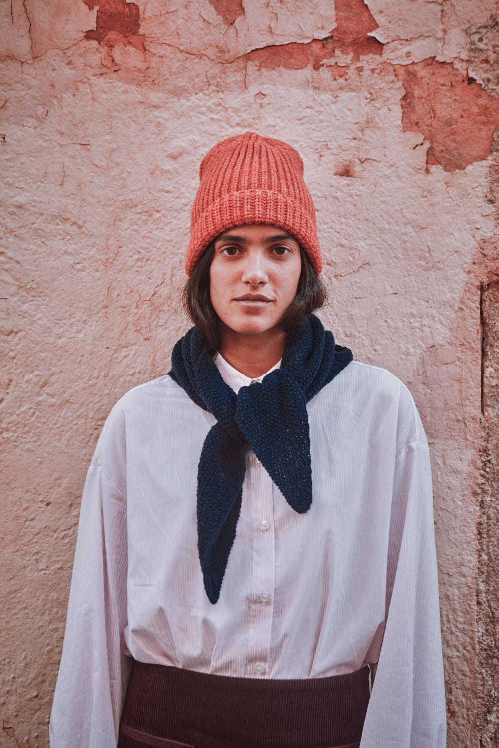 Person wearing a pink beanie and navy scarf 