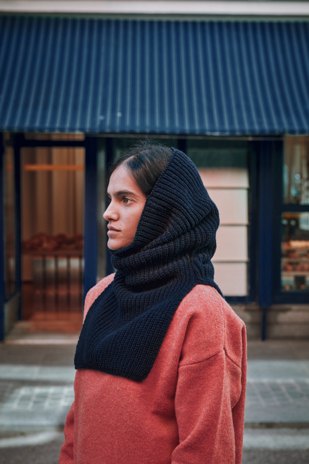 Person wearing a navy knitted scarf in an urban setting