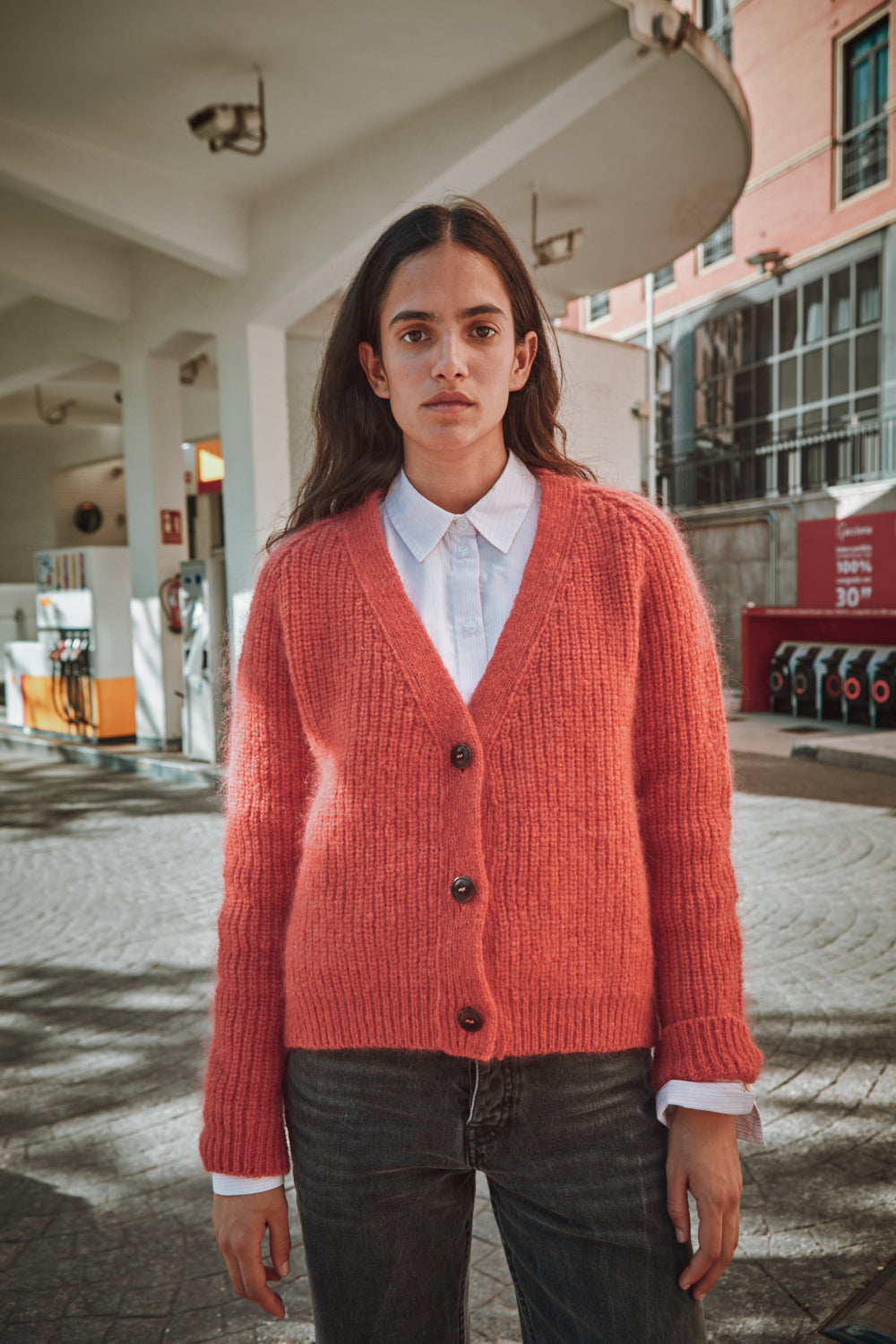 Personne portant un gilet rouge sur une chemise blanche en milieu urbain