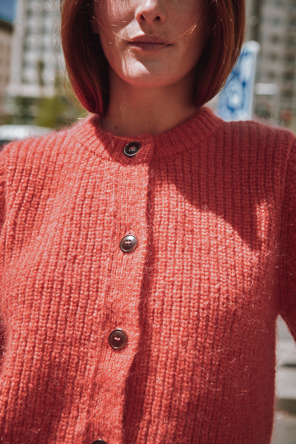 Personne portant un gilet rouge en tricot sur fond flou