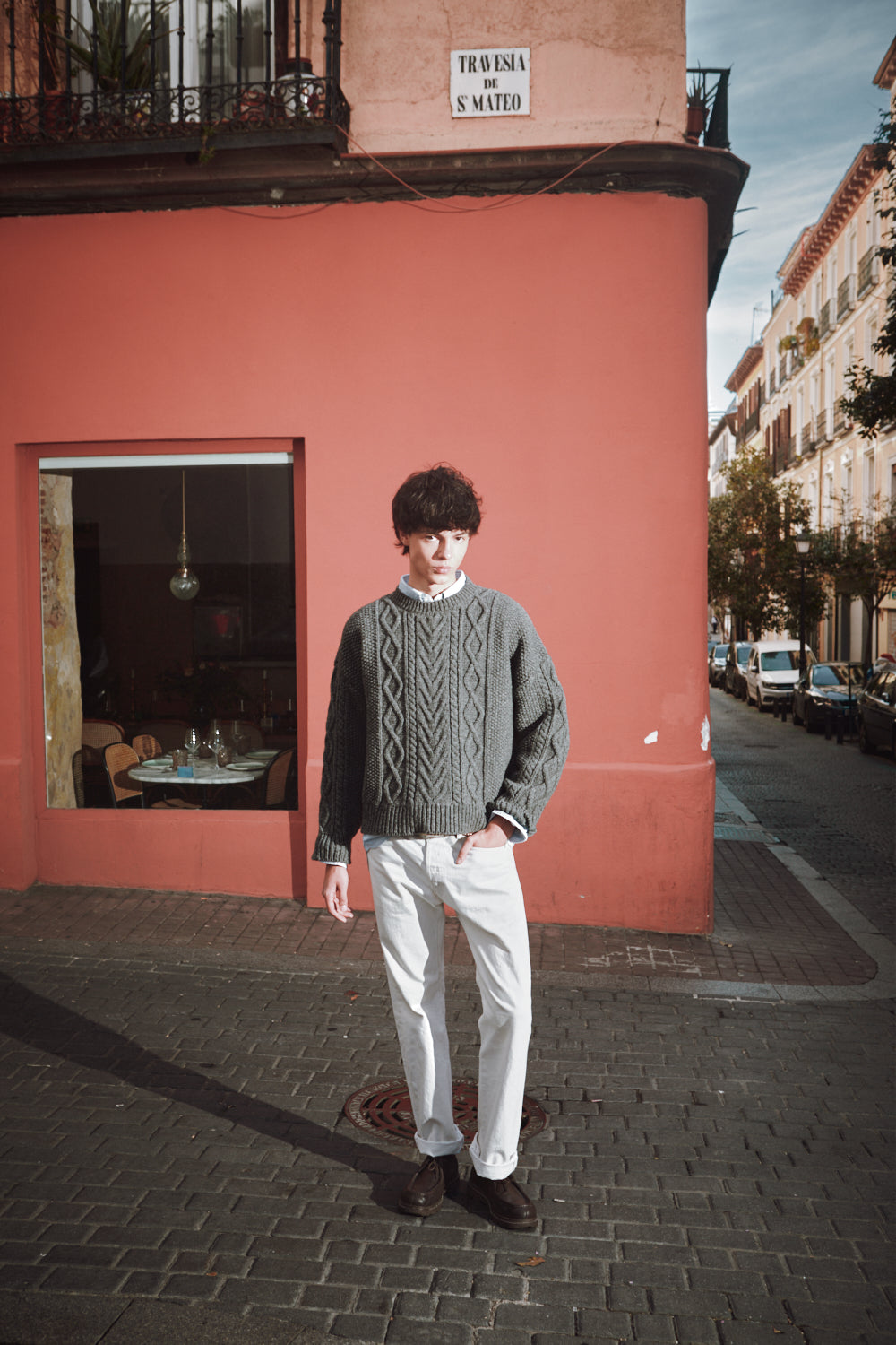 Homme portant un pull motifs irlandais sur fond rose